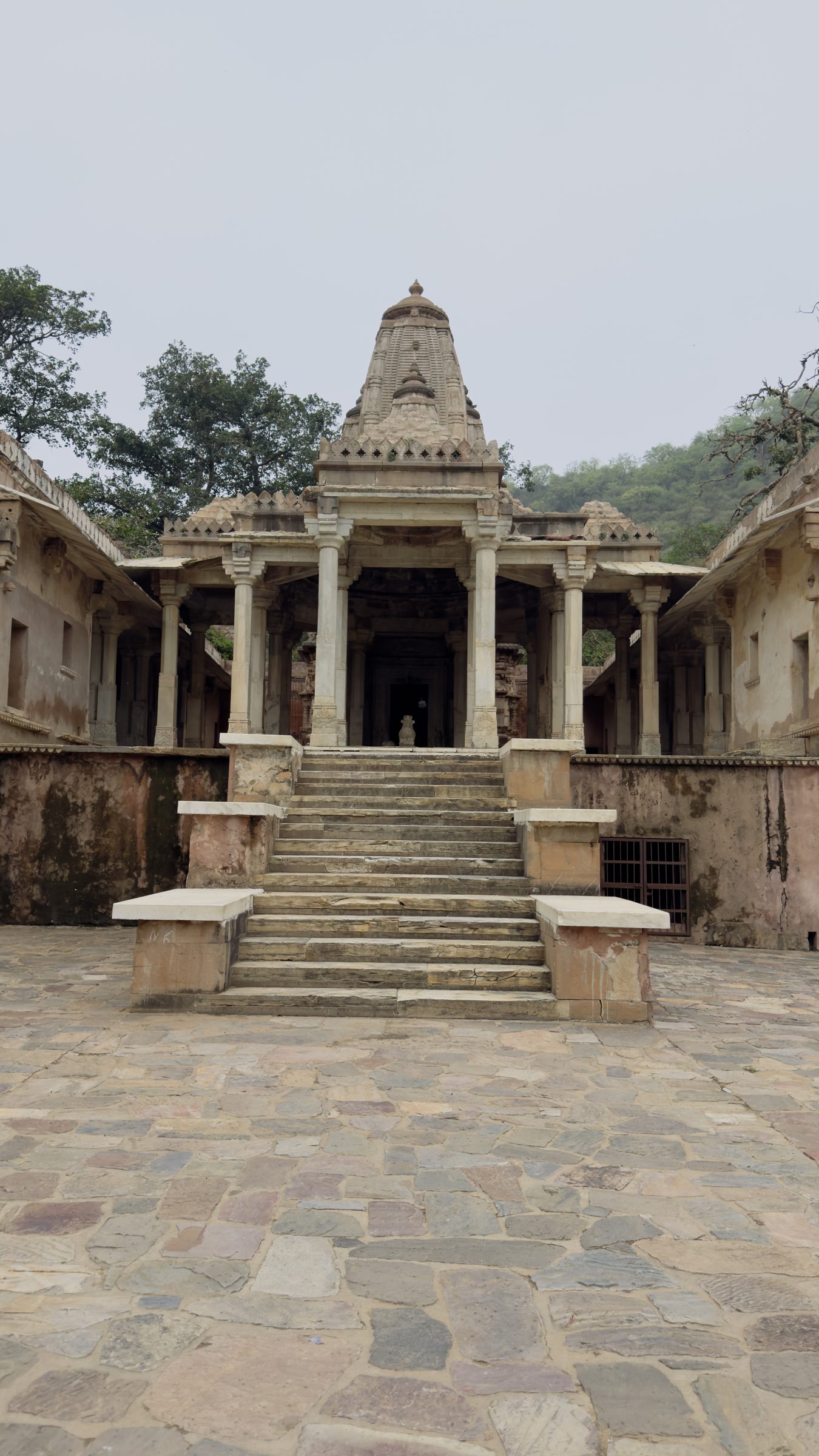 Stone steps leading up to a pillared temple in a paved courtyard at Bhangarh